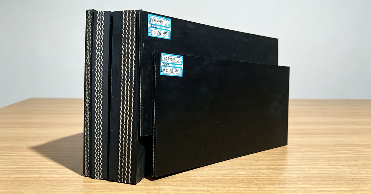 Cross section sample of fabric rubber conveyor belt, showing internal textile ply layers